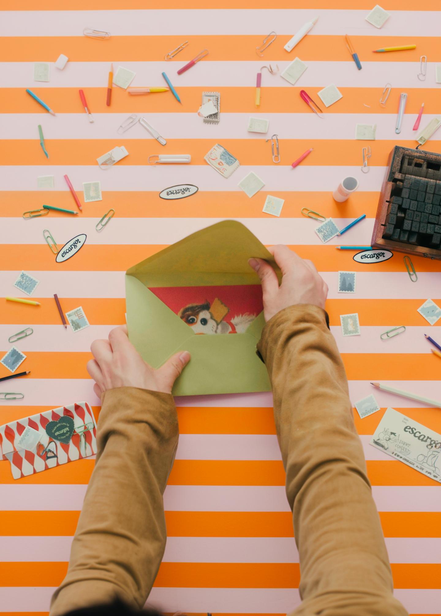 A card being placed into a kraft paper envelope
